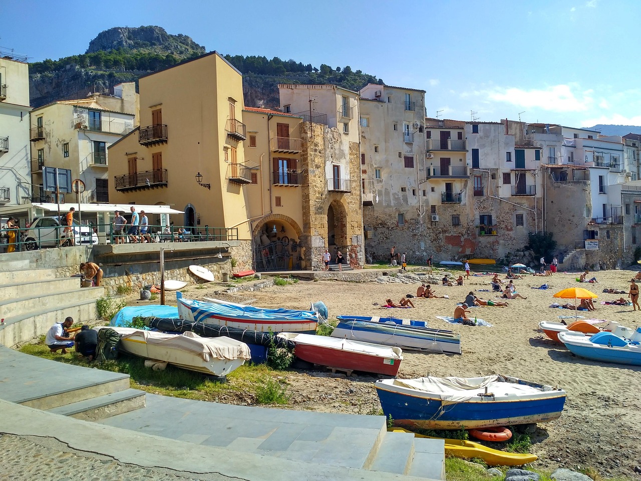 Spiaggia di Mondello in autunno, con acque calde e sole che illumina la sabbia dorata.