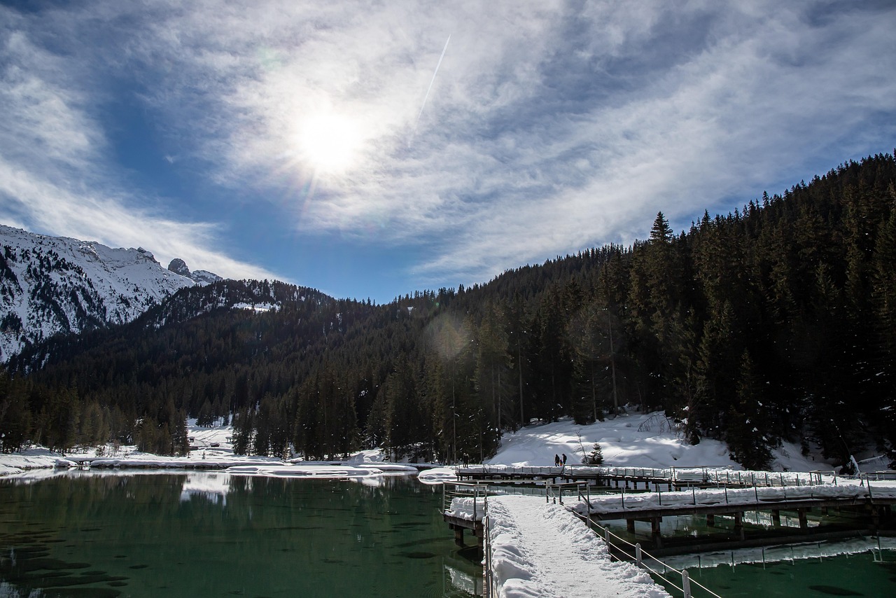 Lago di Tovel con acque turchesi circondato da montagne, simbolo della bellezza delle Alpi.