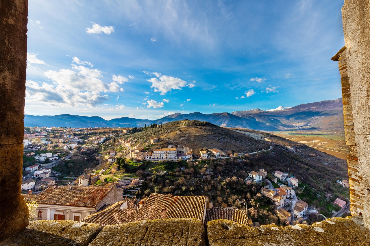 Vista panoramica di Gangi, con case in pietra e l'Etna sullo sfondo.